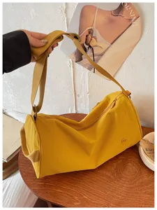 Détail du sac bandoulière cylindrique en nylon jaune, sac crossbody décontracté en vue.