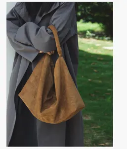 Casual brown suede underarm bag detail, vintage slouchy tote design for daily women wear.