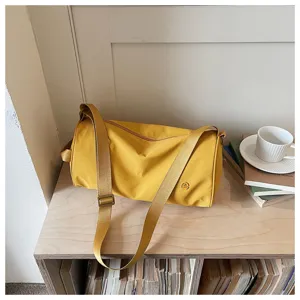 Vue détaillée du sac bandoulière cylindrique en nylon jaune, style mode quotidienne.