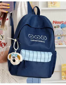 Detailansicht eines süßen dunkelblauen Schulrucksacks mit Streifentasche und Bärenstickerei.