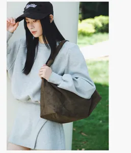 Detail shot of a brown suede hobo shoulder bag worn by model, showcasing daily casual styling.