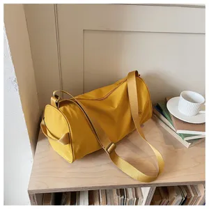 Vue détaillée du sac polochon jaune en nylon avec un tissu très résistant et sa solide sangle.