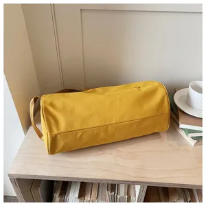 Vue détaillée du sac épaule cylindrique en nylon jaune, idéal pour les déplacements quotidiens.