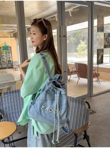 Korean vintage washed denim backpack with drawstring closure and stylish letter embroidery for daily use.