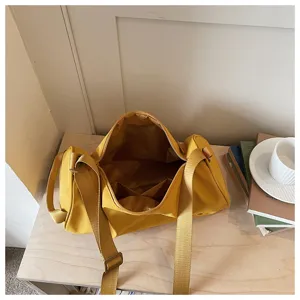 Vue détaillée du sac bandoulière cylindrique en nylon jaune élégant pour femme avec grand espace.