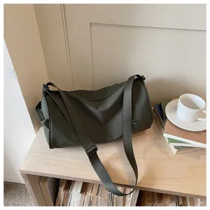 Sac bandoulière cylindrique en nylon vert avec large sangle, sac quotidien élégant et spacieux.