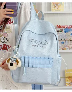 Detailansicht des hellblauen Studentenrucksacks mit Bärenstickerei und Hundeschlüsselanhänger.