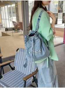 Vintage denim backpack for women, casual student school bag with drawstring and unique design.