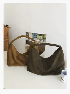 Detailed view of casual suede hobo shoulder bags in brown and dark green, minimalist design.