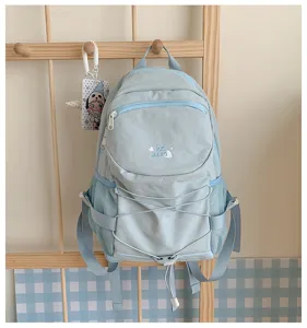 Light blue casual backpack with drawstring and mesh side pockets, stylish campus school bag.