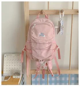 Pink canvas casual backpack with front bungee cord and mesh side pockets for daily school use.