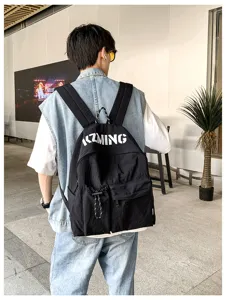 Detailaufnahme des lässigen schwarzen Rucksacks mit großem Fassungsvermögen und Buchstaben.