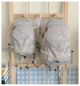 Detailed view of casual minimalist school backpack with front pocket and bungee cord design.