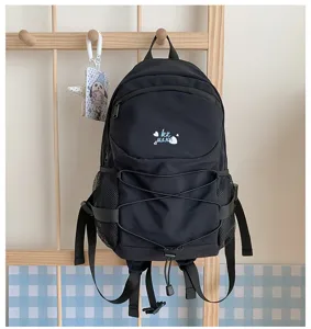 Detailed view of the black canvas casual backpack with drawstring and side mesh pockets.