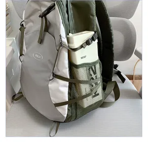Detail view of lightweight foldable hiking backpack in grey and green with side mesh pocket.