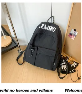 Detailansicht des schwarzen Nylon-Reiserucksacks mit Fronttaschen, Kordelzug und weißem Logo.