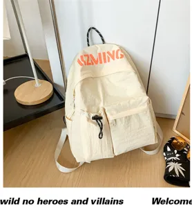 Detailansicht des cremefarbenen Canvas-Freizeitreucksacks mit Kordelzug und Vordertaschen.