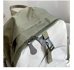 Detailed view of lightweight backpack double zipper, buckle and waterproof fabric texture.