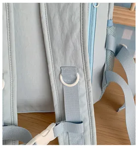 Light blue backpack strap detail with D-ring and buckle, casual daily school bookbag close up.