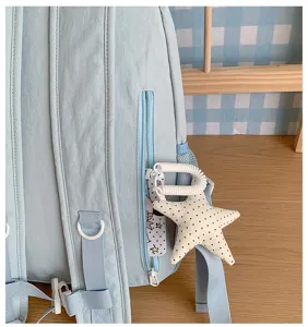 Light blue casual school backpack with star plush pendant and side zipper pocket.