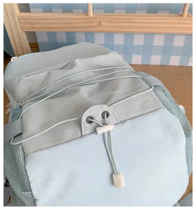 Light blue grey casual backpack detail showing elastic drawstring and mesh pocket.
