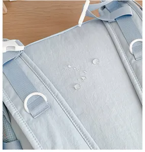 Close-up detail of light blue waterproof backpack fabric and adjustable buckle structure.