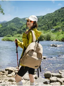 Détail de style de vie en plein air montrant un sac à dos minimaliste près de la rivière.