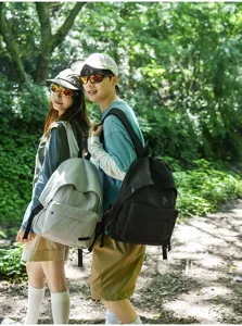 Vue détaillée d'un couple portant des sacs à dos de loisirs minimalistes en forêt.