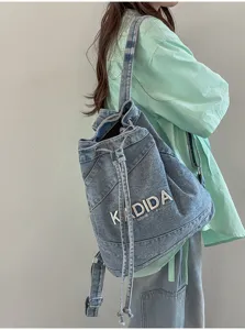 Detail view of casual retro denim backpack with drawstring closure and washed finish.