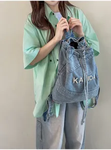 Vintage washed denim backpack for women, casual student school bag with drawstring design.