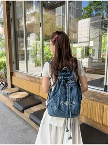 Vintage washed denim backpack for women, casual school bookbag with drawstring and pocket.