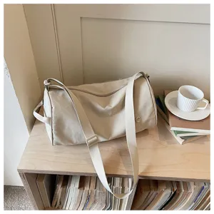 Sac bandoulière cylindrique en nylon minimaliste, sac de voyage et de travail chic.