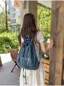 Vintage washed denim backpack detail showing urban street style and large capacity design.