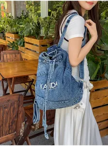 Vintage washed denim backpack detail view, casual style large capacity student commuter bag.
