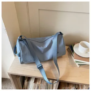 Vue détaillée du sac porté épaule cylindrique en nylon bleu clair, sac bandoulière.