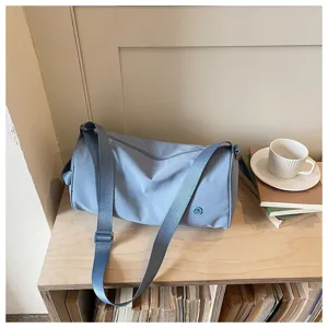 Sac bandoulière cylindrique minimaliste en nylon bleu, sac de messager décontracté quotidien.