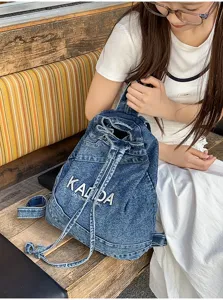 Vintage washed denim backpack for women, casual large capacity school bag with drawstring closure.