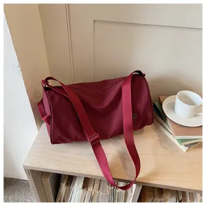 Vue détaillée d'un sac bandoulière cylindrique en nylon minimaliste pour le quotidien.