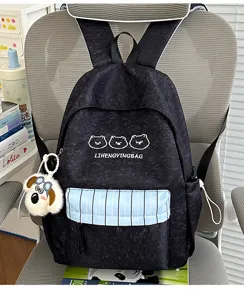 Detailansicht eines niedlichen japanischen Fareblock-Rucksacks mit Bärenstickerei und Plüschanhänger.