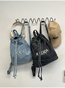 Close-up details of vintage washed denim backpack showing drawstring and fabric texture.