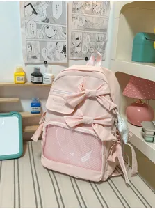 Detalle de mochila ita rosa con bolsillo de red transparente y lazos bonitos.