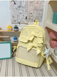 Detalle de bolso ita amarillo claro con bolsillo transparente y lazos decorativos.