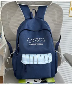 Detailansicht des dunkelblauen süßen Schulrucksacks mit Bärenstickerei und gestreifter Vordertasche.