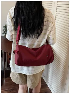 Vue détaillée du sac à bandoulière cylindrique en nylon rouge élégant de grande capacité mode.