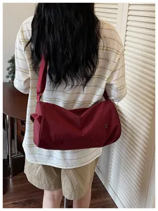 Sac bandoulière cylindrique en nylon rouge foncé, sac crossbody décontracté pour femmes.