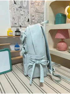 Vista lateral detallada de la mochila azul claro con bonito lazo y diseño elegante.