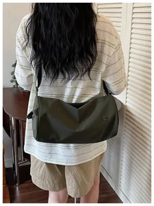 Vue détaillée du sac bandoulière cylindrique en nylon décontracté et style quotidien.