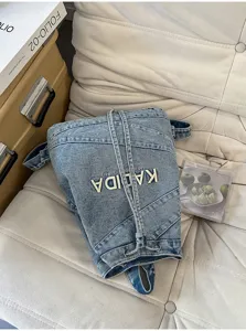Detailed view of vintage washed denim backpack featuring drawstring closure and embroidery.