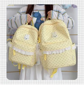 Detailansicht des süßen gelben gepunkteten Rucksacks mit weißem Hasen-Patch und Spitzenbesatz.