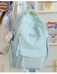 Lichtblauwe studentenrugzak detail, schattig strik borduurwerk en kwast rits, grote schooltas.